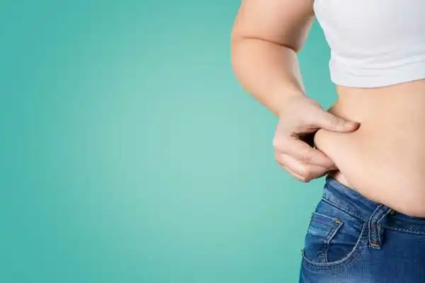 Image of woman pinching her love handles to show weight gain Wentworth